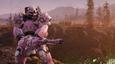 A pink and white robot holding a large gun in the wasteland of Fallout 76.